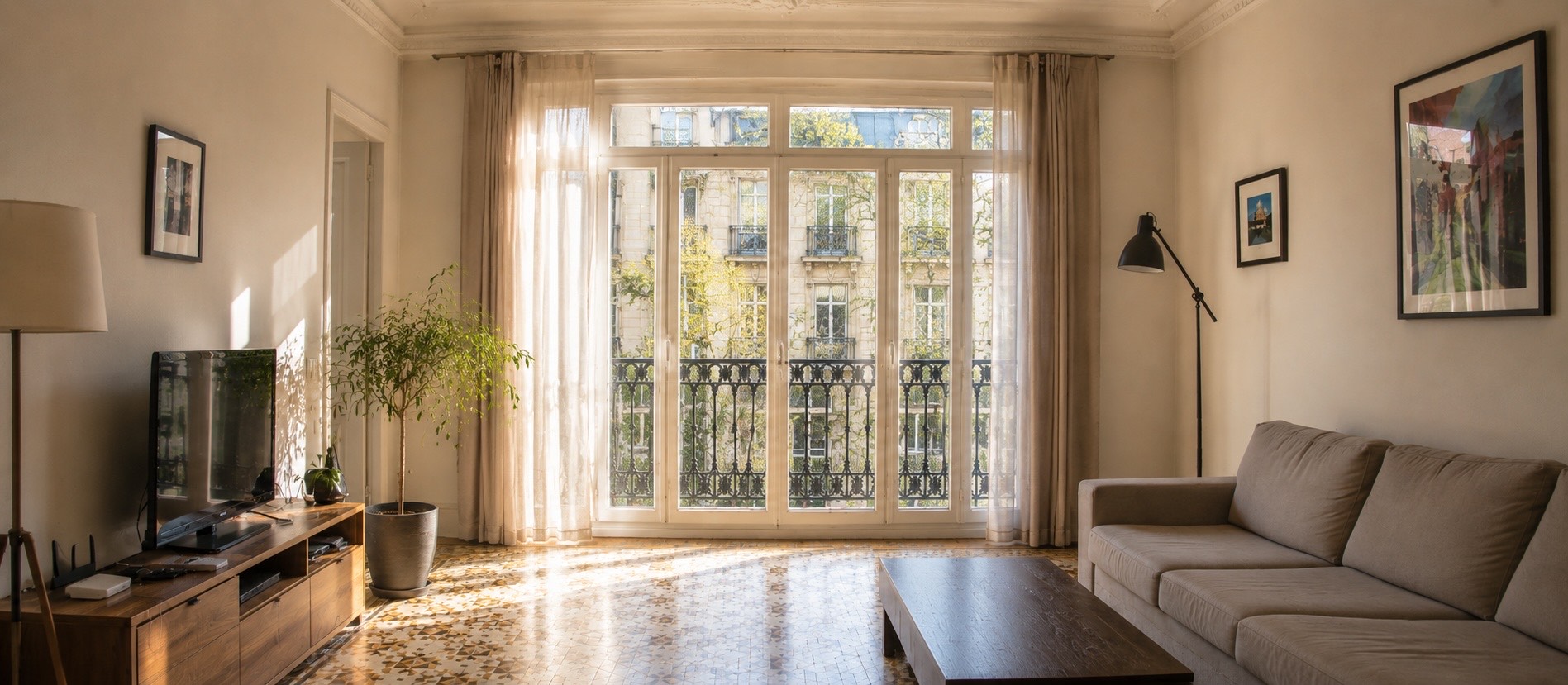El mismo salón despejado, con el sol entrando hasta el fondo y el suelo hidráulico reflejando la luz